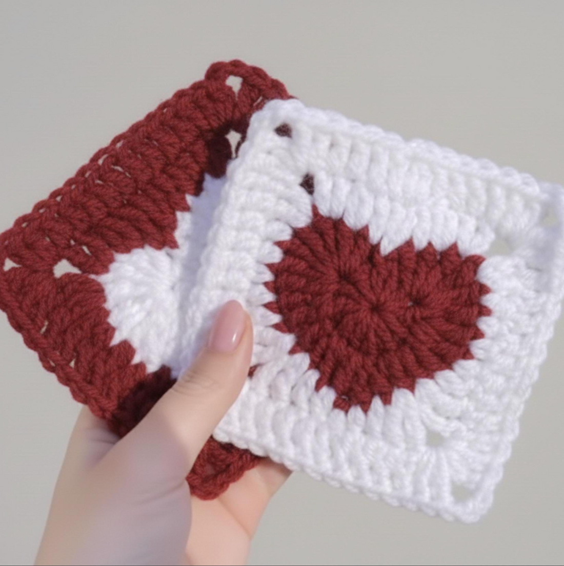 White crochet granny squares with red heart centers on a wooden table, PDF pattern with video tutorial